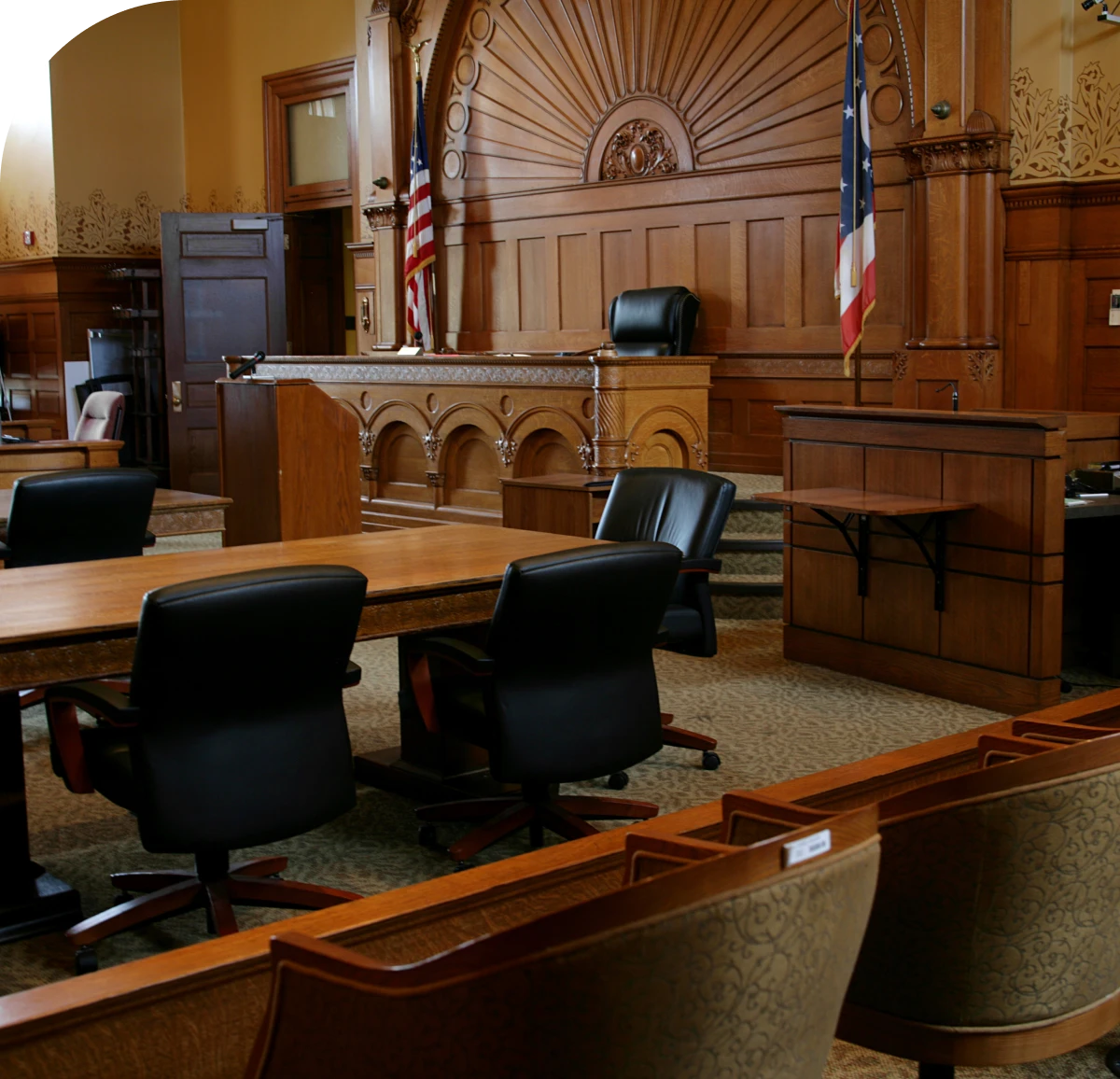 Empty courtroom with judge's bench and flags.