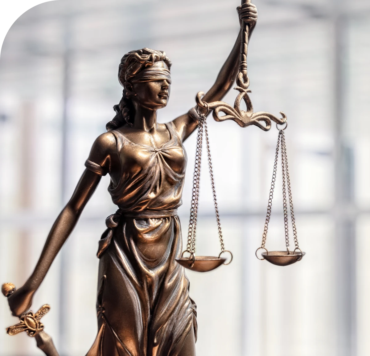 Blindfolded Lady Justice holding scales statue.