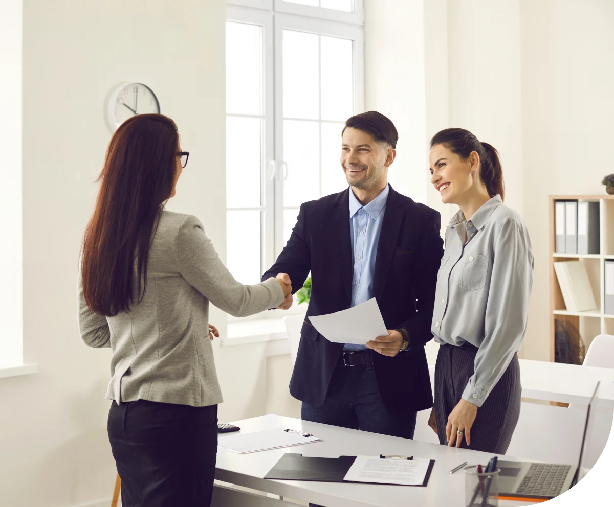 Office meeting with handshake and smiles.