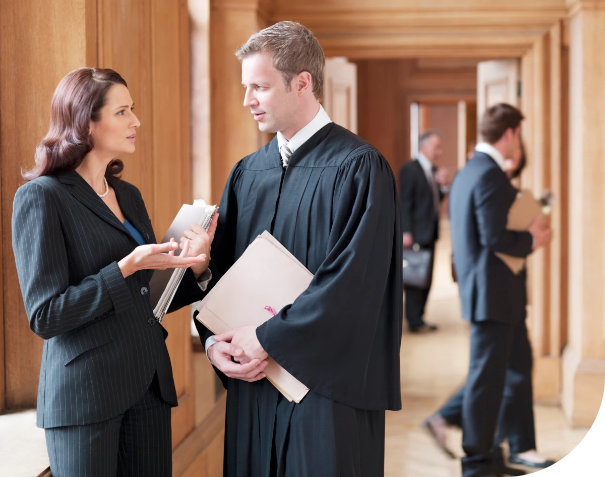 Lawyers conversing in courthouse hallway.